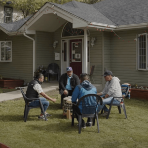 Four indigenous men drumming in front of Sanctum.